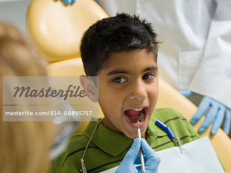 Dentist examining young patient's teeth