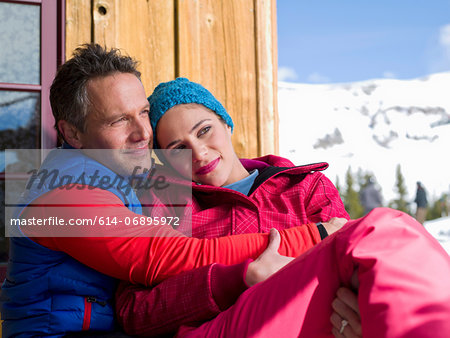 Mature man and young woman relaxing together at ski resort