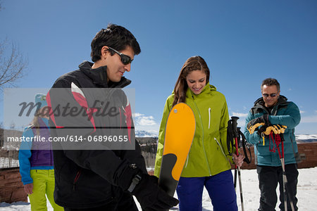 Mature man and young woman with ski instructors on ski slope