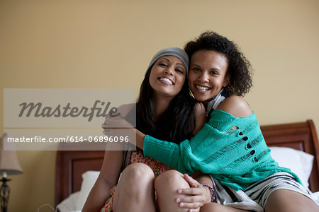 Young women embracing on bed, portrait
