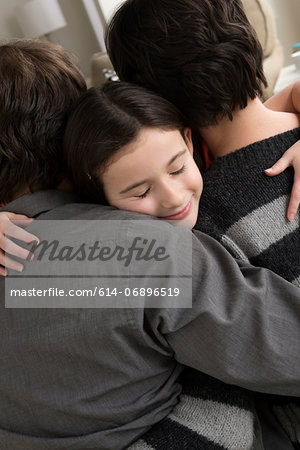 Parents hugging daughter