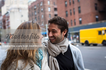 Smiling couple walking down city street