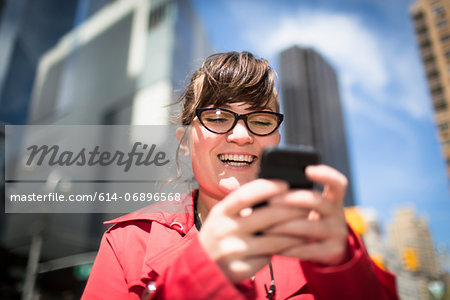 Portrait of woman in city looking at smartphone