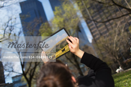 Woman in city park looking at digital tablet screen