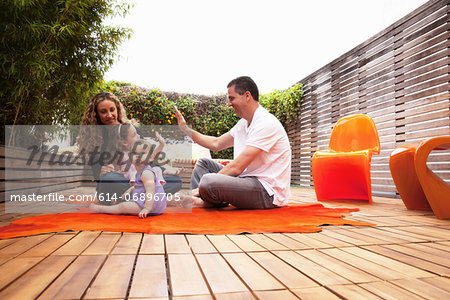 Family sitting on rug on patio