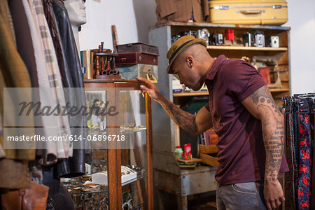 Young man looking into cabinet in vintage shop
