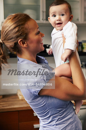 Mother holding baby girl, smiling