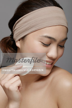 Young woman using make up sponge