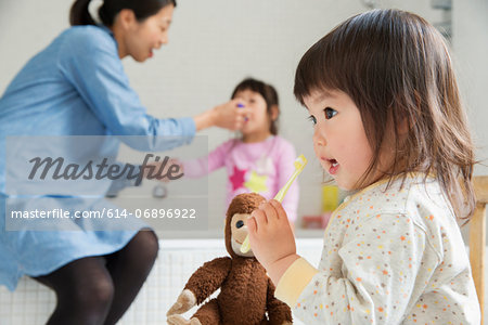 Female toddler with cuddly toy and toothbrush