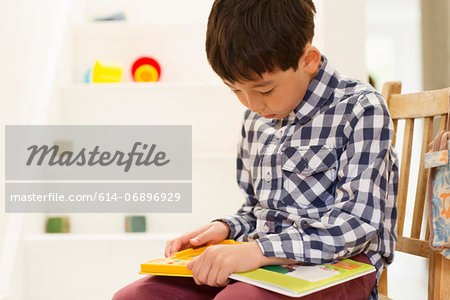 Young boy sitting on chair studying game