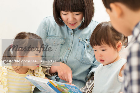 Mother and children looking at storybook