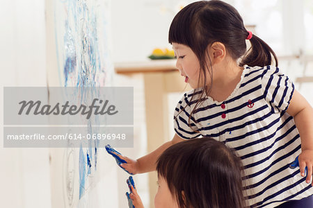 Two young sister making handprint painting
