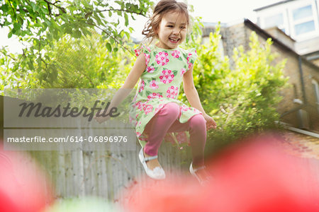 Young girl jumping mid air in garden
