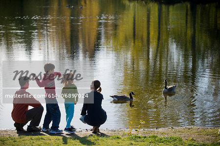 Family in park feeding ducks