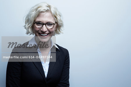 Studio portrait of blond businesswoman smiling