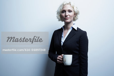 Studio portrait of blond businesswoman holding mug of tea