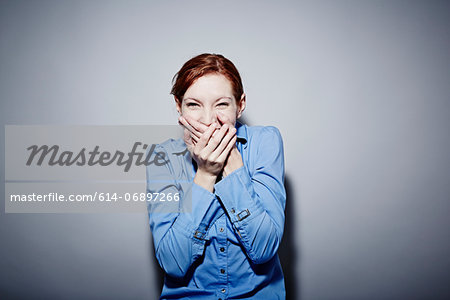 Studio portrait of young woman giggling