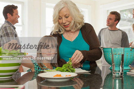 Granddaughter and grandmother preparing salad