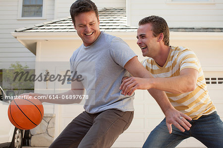 Father and adult son playing basketball Father and adult son playing basketball