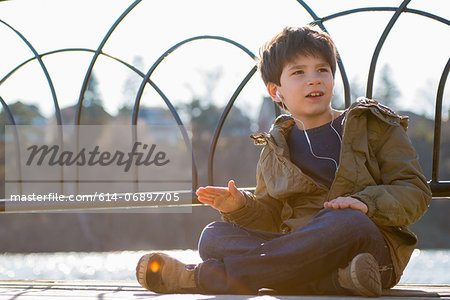 Boy sitting cross legged wearing earphones