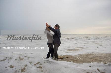 Mature couple dancing on beach