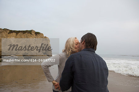 Mature couple kissing on beach