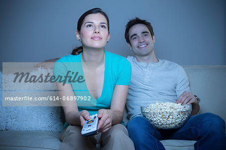 Couple watching television with popcorn