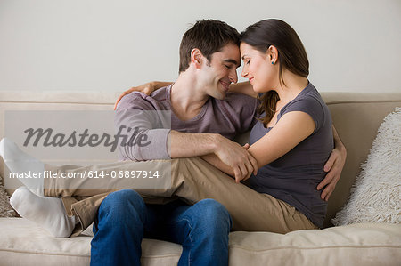 Couple on sofa, woman sitting on man's lap