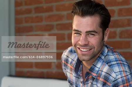 Young man wearing checked shirt, smiling