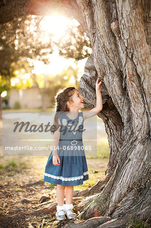 Portrait of girl touching tree trunk Portrait of girl touching tree trunk
