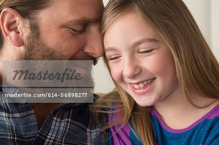 Father leaning face on daughter's head