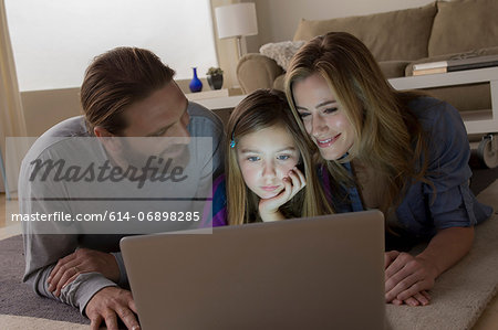 Parents and child looking at laptop