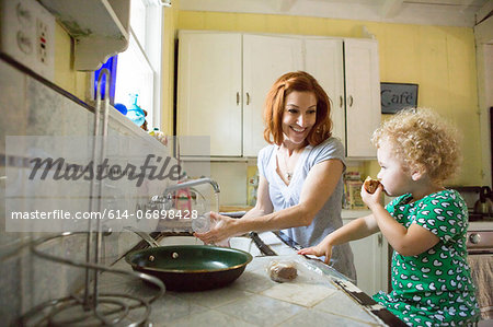 Mother at sink smiling at child