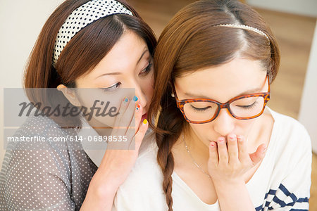 Woman whispering to friend