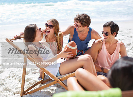 Happy friends with football hanging out at beach Happy friends with football hanging out at beach