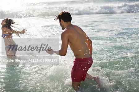 Couple splashing in ocean