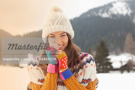 Portrait of smiling woman wearing knit hat in snowy field