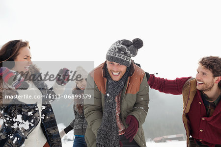 Playful friends enjoying snowball fight