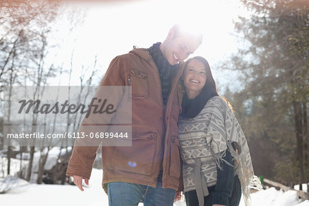 Happy couple hugging in snowy woods