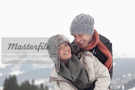 Portrait of enthusiastic couple hugging with mountains in background