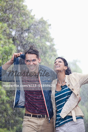 Happy couple walking in rain