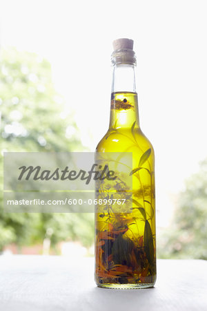 Still life of bottle of olive oil with herbs on window sill, Germany