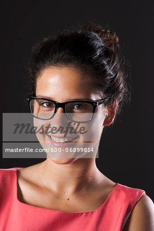 Portrait of teenage girl wearing horn-rimmed eyeglasses, smiling and looking at camera