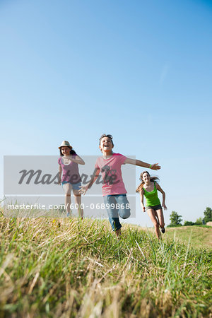 Girls running in field, Germany