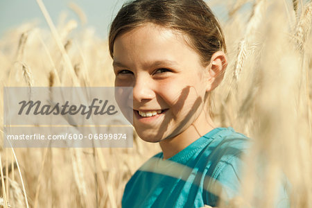 Close-up portrait of girl standing in wheat field, Germany