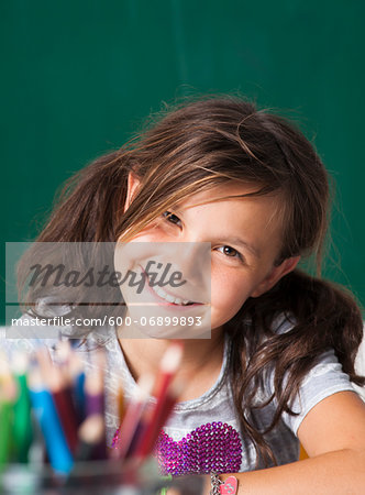 Close-up portrait of girl sitting at desk in classroom, Germany