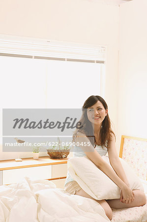Woman sitting on bed smiling away