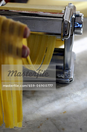 Tagliatelle being cut with a pasta machine