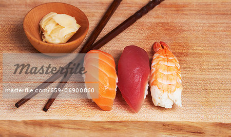 Sashimi Sushi (Salmon, Tuna, Shrimp) on Wood Board with Ginger and Chopsticks
