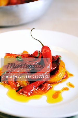 A plate of pan cooked sweet red and yellow peppers with fresh chilies and sun dried tomatoes